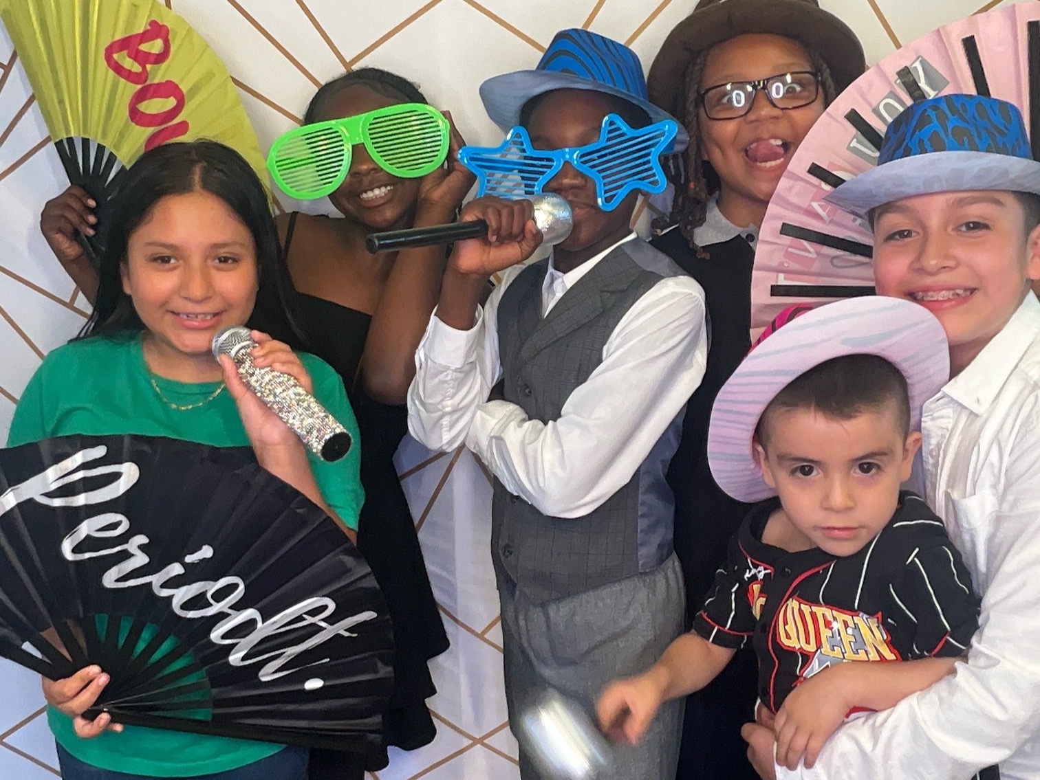 Group enjoying colorful photo booth props at a school event
